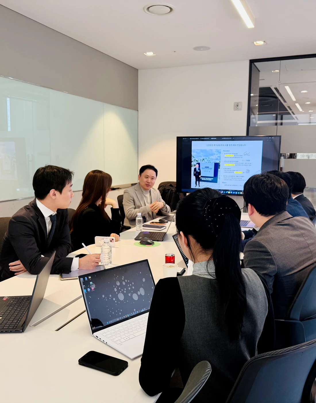 신영증권 투자개발부 AI 교육 현장에서 노트북을 펼친 실무진과 강사가 회의 테이블에서 함께 이야기하는 모습